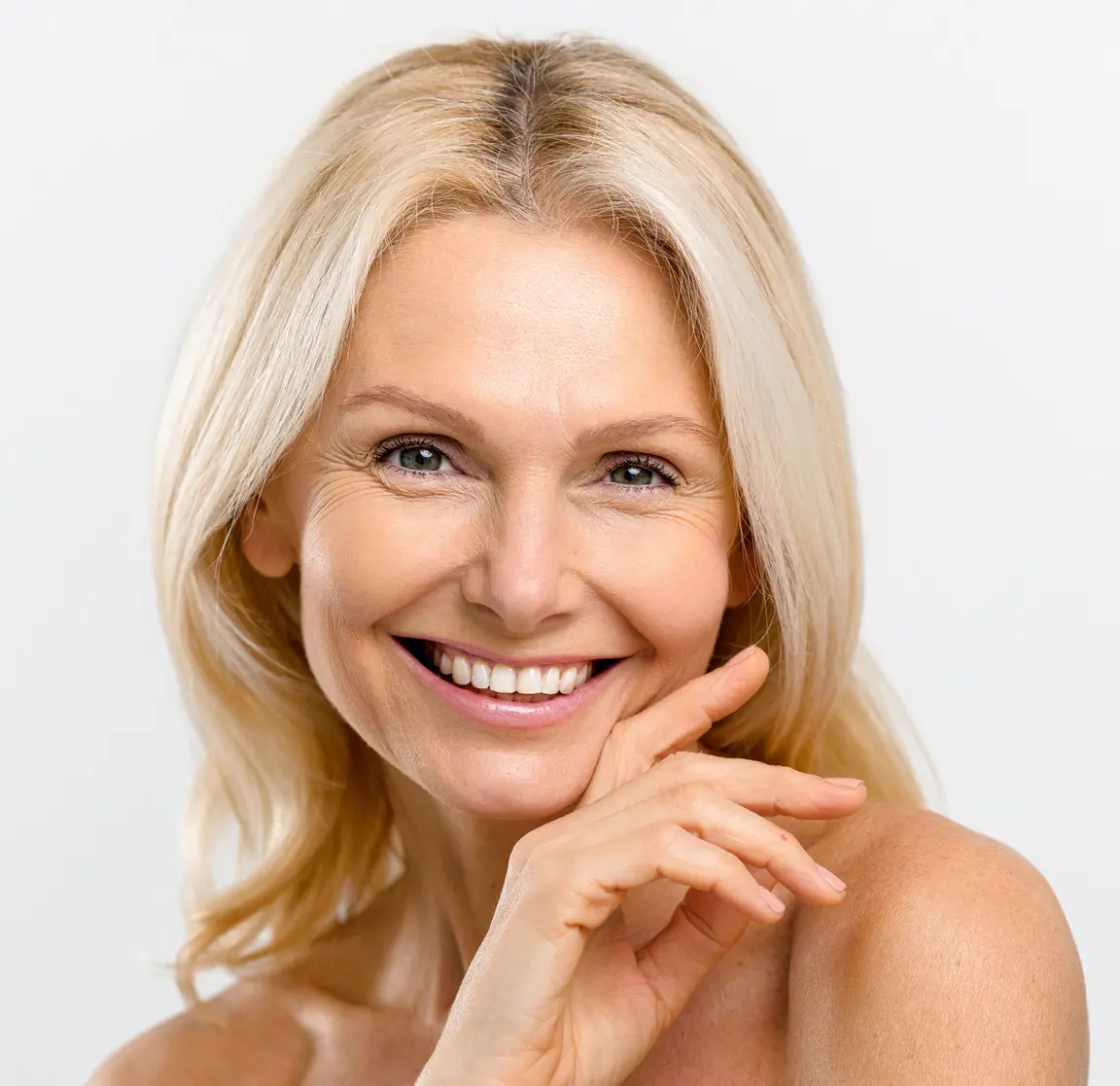 Portrait of fresh and gorgeous middle-aged woman with pure and healthy skin and blonde hair, stands with a naked shoulders isolated on white background, mature lady looks at camera Xeomin in West Palm Beach and Jupiter, FL
