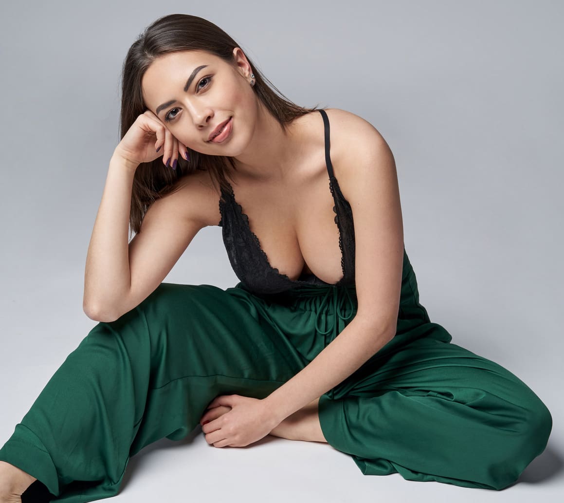 Sensual brunette female in green trousers and top with deep cleavage Fat Transfer and Injections in West Palm Beach and Jupiter, FL